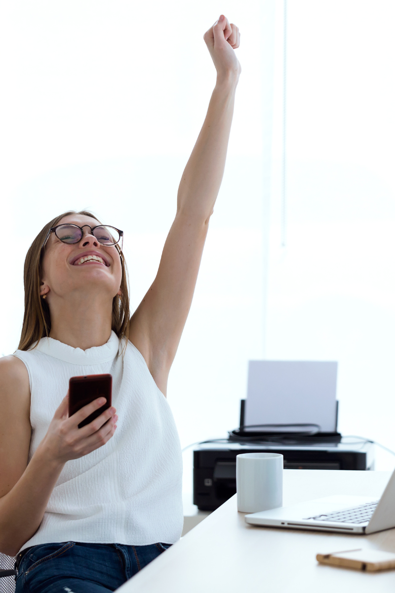 Woman celebrating her realization that she's ready to become a freelance writer, with her fist pumped happily into the air. Woman celebrating her realization that she's ready to become a freelance writer, with her fist pumped happily into the air.