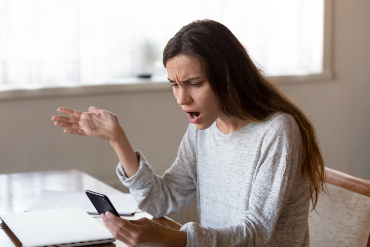 Woman exhibiting one of the signs of a toxic client by threatening her freelance beauty copywriter via phone. Woman exhibiting one of the signs of a toxic client by threatening her freelance beauty copywriter via phone.